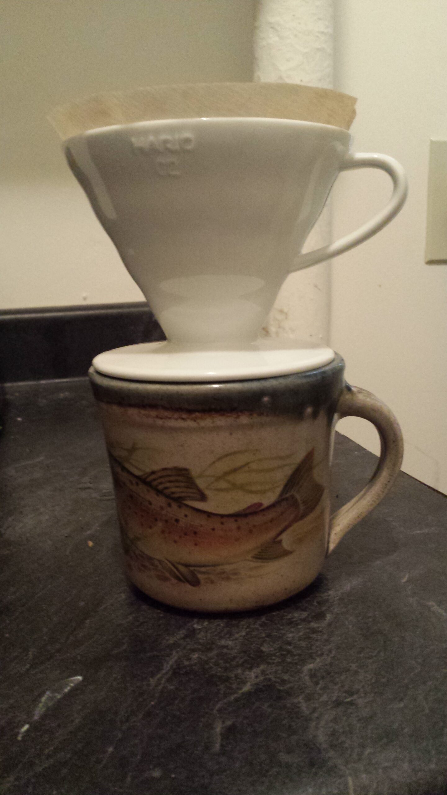 Coffee being brewed in a paper-lined Hario V60 drip cone.