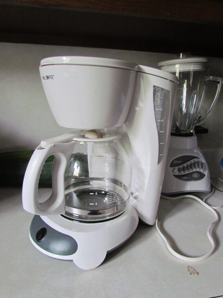 White Mr. Coffee drip coffee maker with a glass carafe.