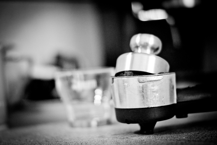 Espresso tamper resting on the basket of a home-machine portafilter.